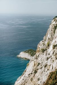 High angle view of rocks by sea against sky