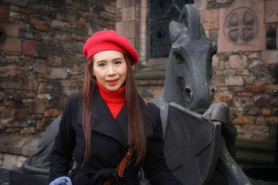 Portrait of woman standing against statue