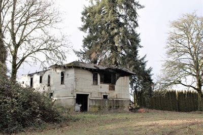Abandoned house on field against sky
