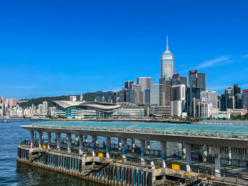 Buildings in city against clear blue sky
