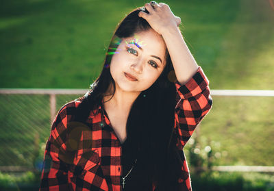 Portrait of beautiful woman standing against blurred background