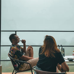 Rear view of people sitting on chair