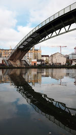 Bridge over river in city against sky