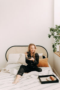 Portrait of a young woman using mobile phone at home