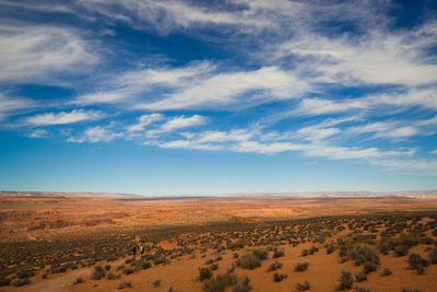 Scenic view of desert against cloudy sky