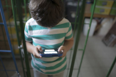 High angle view of plying video game while standing at home