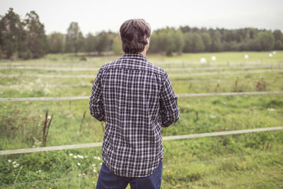 Rear view of man standing at organic farm