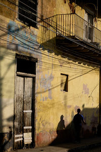 Rear view of men sitting on wall of building