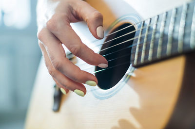 Midsection of man playing guitar