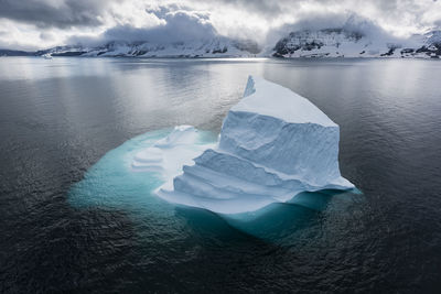 Iceberg in sea against sky