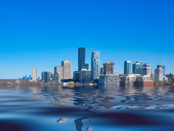 Modern buildings in city against clear blue sky