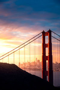 View of suspension bridge against cloudy sky