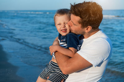 Father kissing son at beach