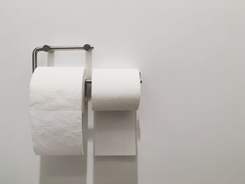 Close-up of toilet papers on white wall