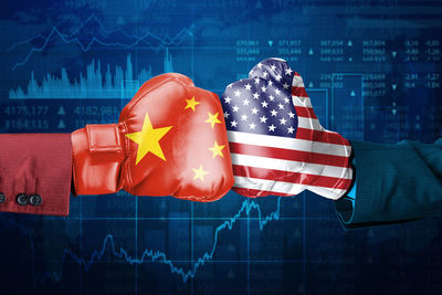 Cropped hands wearing boxing gloves with chinese and american flags against graph