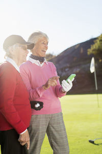 Senior female golfers smiling on golf course