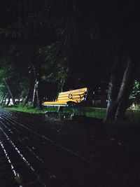 Empty bench in park at night