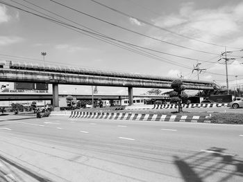 People on railroad tracks against sky in city