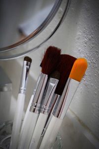 Close-up of make-up brushes in glass container