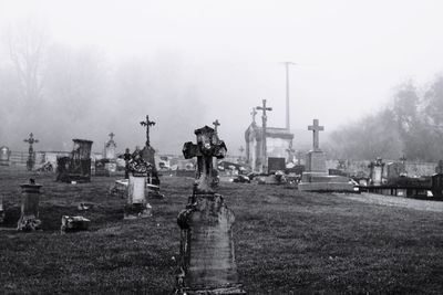 Crosses at cemetery during foggy weather