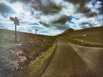 Country road against cloudy sky