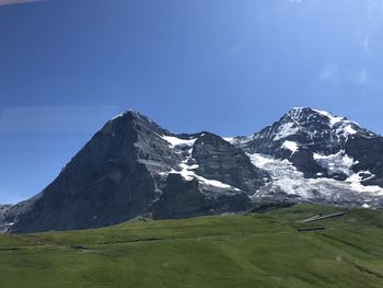 Scenic view of snowcapped mountains against blue sky