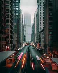 Light trails on road amidst buildings in city