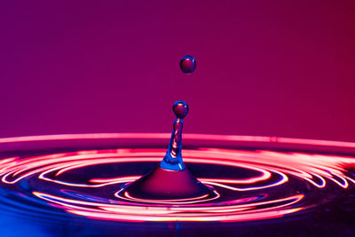 Close-up of drop falling on blue water