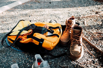 Close-up of shoes and backpack on roadside