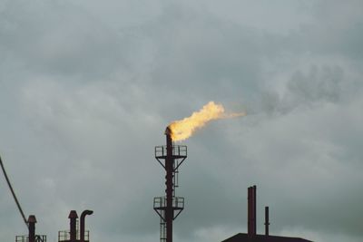 Low angle view of smoke emitting from chimney against sky