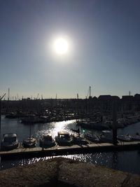 Boats moored at harbor against clear sky during sunset