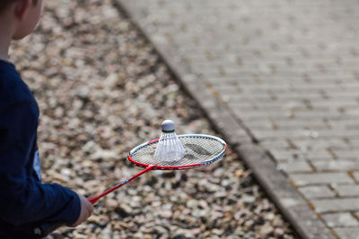 Cropped image of boy holding badminton racket and shuttlecock