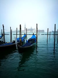 Boats moored on wooden post in water