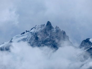 Low angle view of snow covered mountain against sky