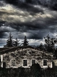 Low angle view of buildings against cloudy sky