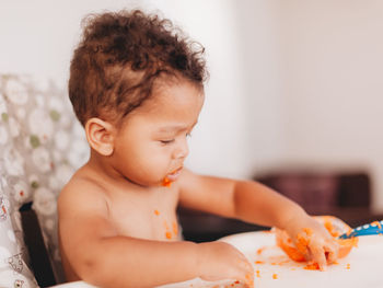 Close-up of cute baby eating food at home