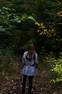 Rear view of woman standing in forest