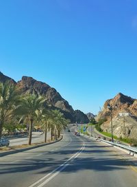 Road against clear blue sky