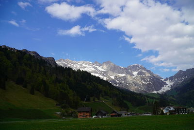 Scenic view of houses and mountains against sky