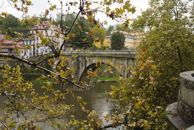 Arch bridge over river amidst buildings in town