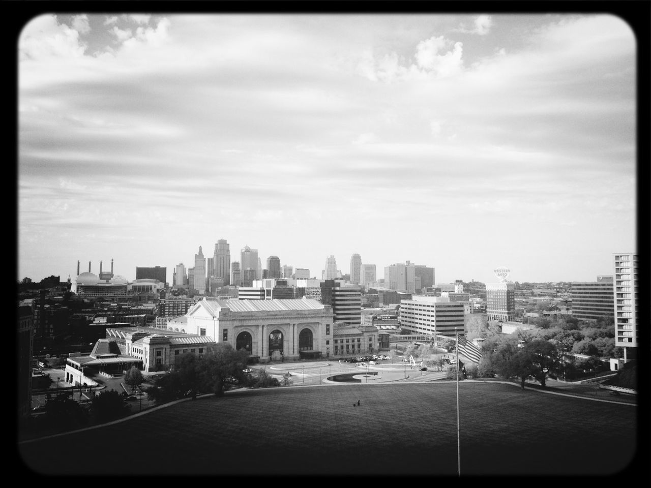 building exterior, architecture, city, built structure, transfer print, sky, cityscape, street, auto post production filter, road, car, cloud - sky, residential building, city life, transportation, residential district, residential structure, skyscraper, high angle view, crowded