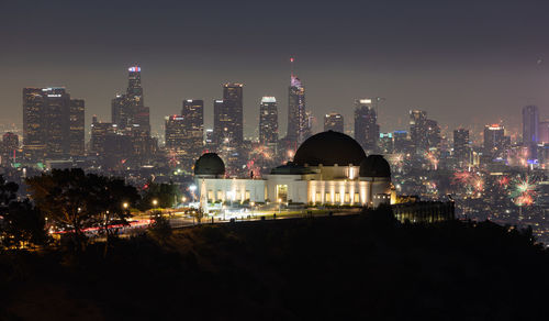 Fourth of july fireworks over griffith observatory with the los angeles skyline in the distance