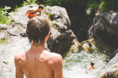 Rear view of shirtless boy in water