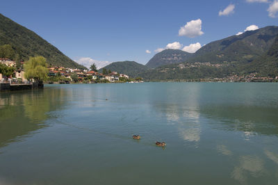 Scenic view of lake by mountains against sky