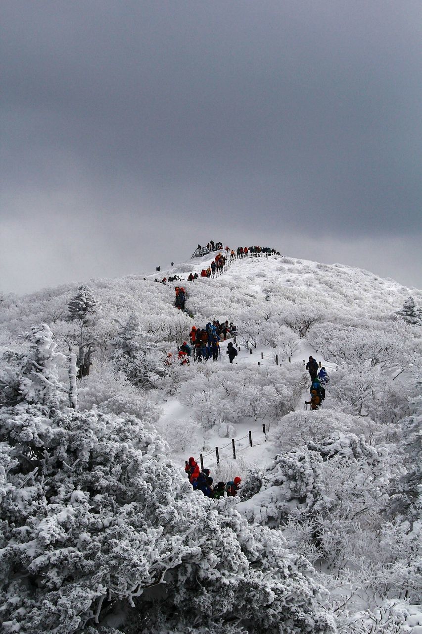 PEOPLE ENJOYING ON SNOWCAPPED MOUNTAIN AGAINST SKY