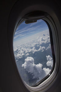 View of cloudy sky seen through airplane window