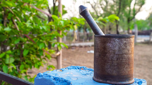 Close-up of rusty container on table in yard