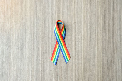 Directly above shot of gay pride ribbon on wooden table