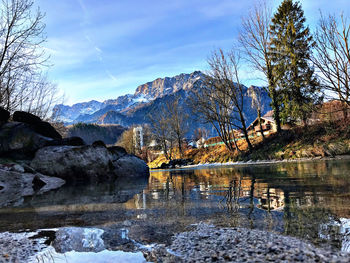 Scenic view of lake by mountain against sky