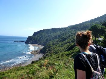 Rear view of woman looking at sea against clear sky